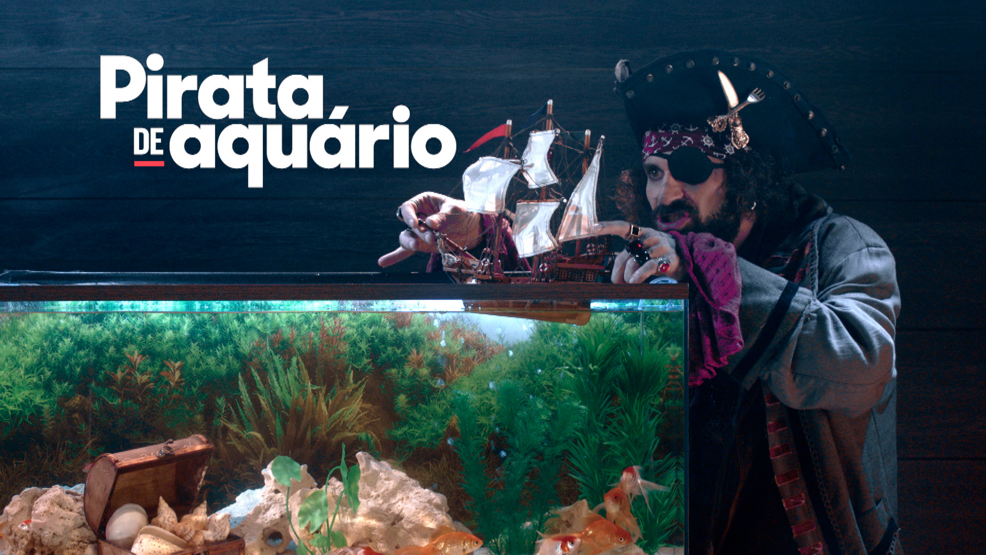 Um pirata brinca com um navio de brinquedo em um aquário