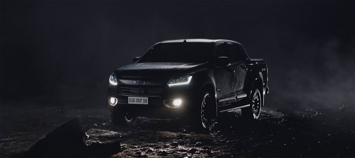 Na imagem, há um Chevrolet S10 Midnight em um ambiente escuro