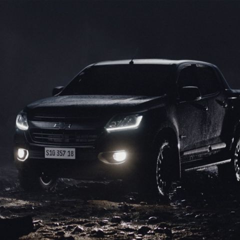 Na imagem, há um Chevrolet S10 Midnight em um ambiente escuro