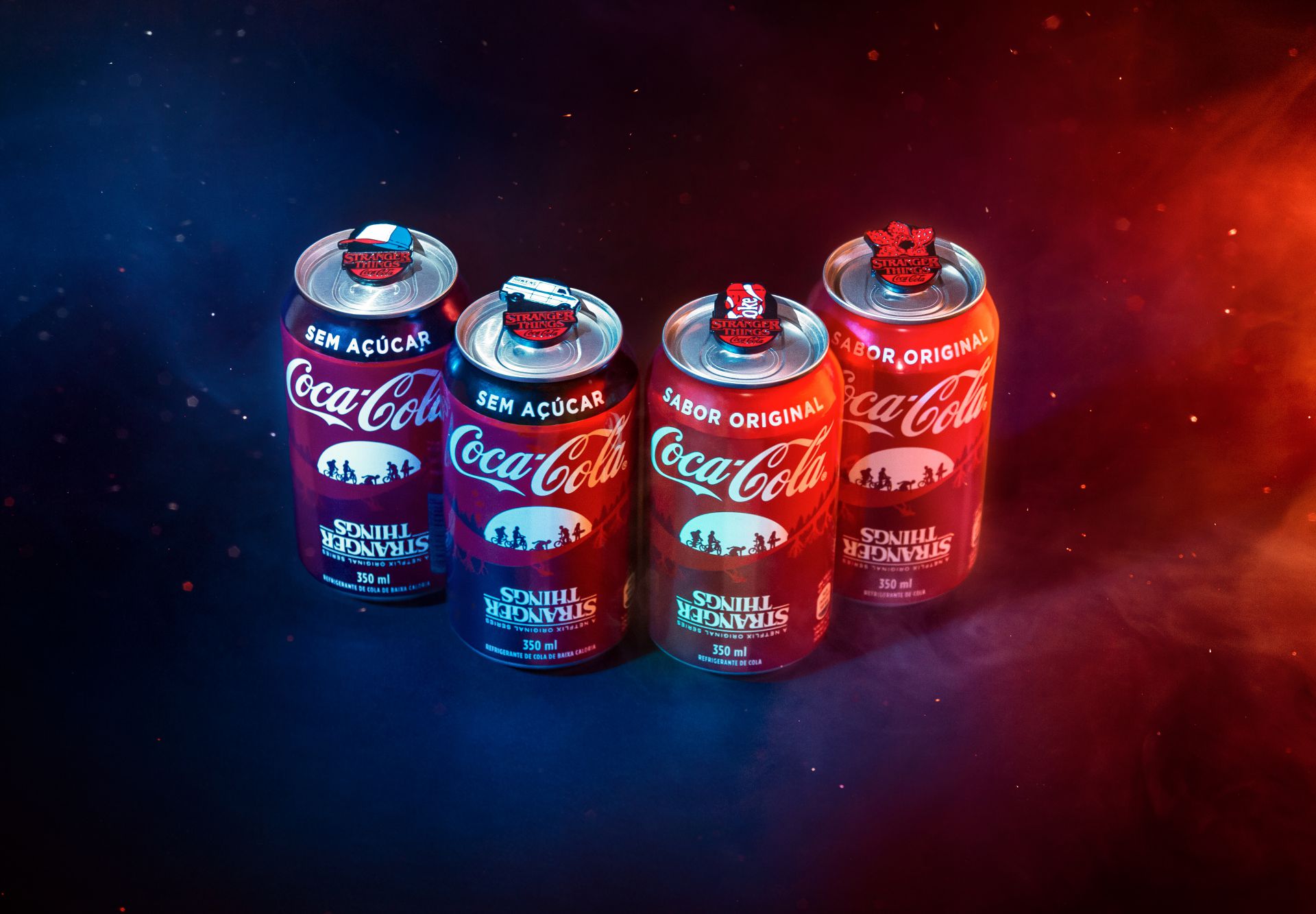 Quatro latas de Coca-Cola Pin Tabs edição Stranger Things, uma do lado da outra.