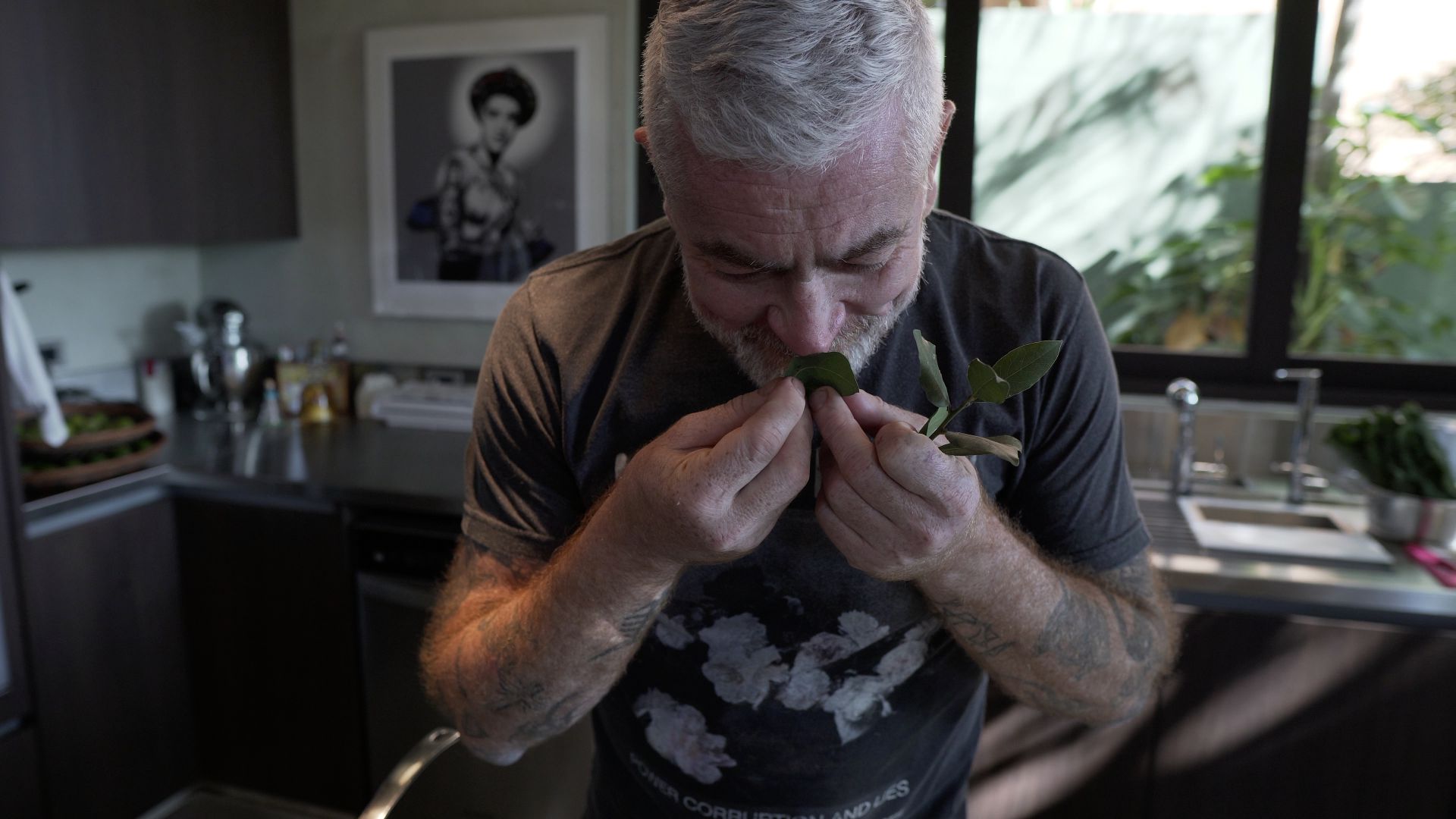 Chef Alex Atala cheira folhas de louro na cozinha de sua casa