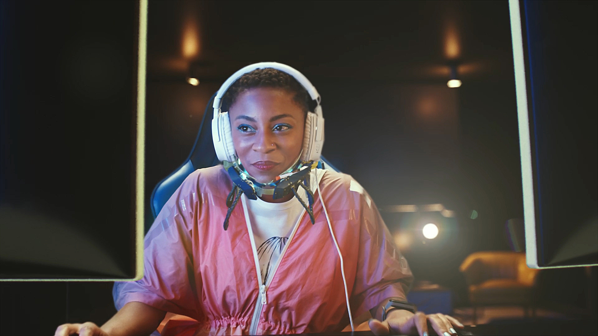 Na imagem, uma moça aparece sorrindo enquanto parece jogar online.